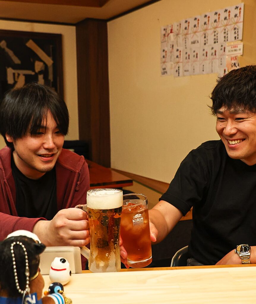 笑顔で乾杯をする男性2人